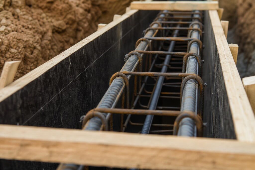 Cage d'armatures en acier HA dans le coffrage d'une longrine en béton armé