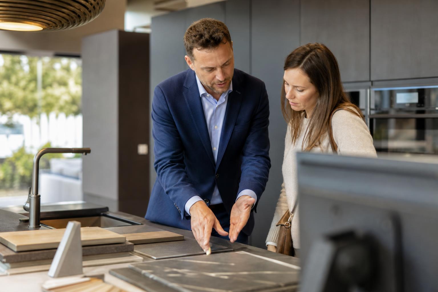Conseiller de magasin aidant un client dans un showroom de cuisine