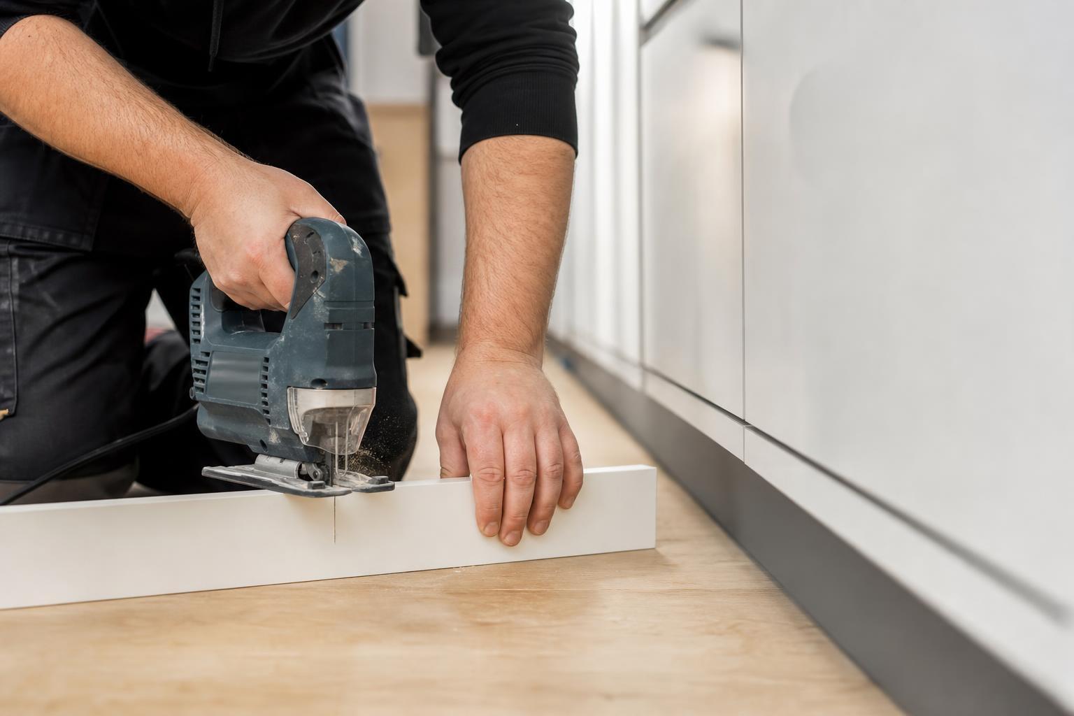 Découpe d'une plinthe de cuisine à la scie sauteuse pour l'ajuster