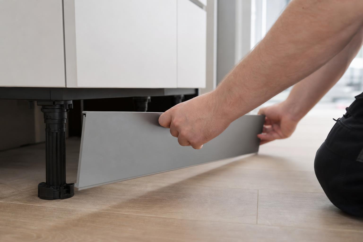 Emboîtement de la plinthe de cuisine sur les clips des pieds