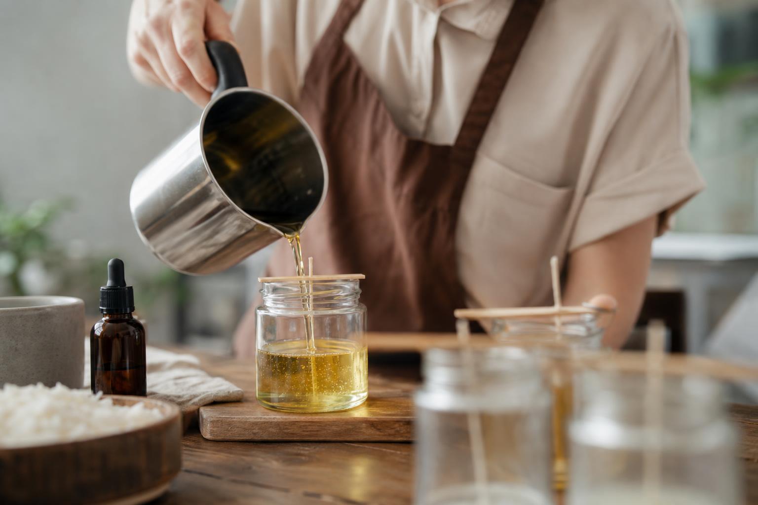 Fabrication d'une bougie parfumée maison en versant la cire dans un pot en verre