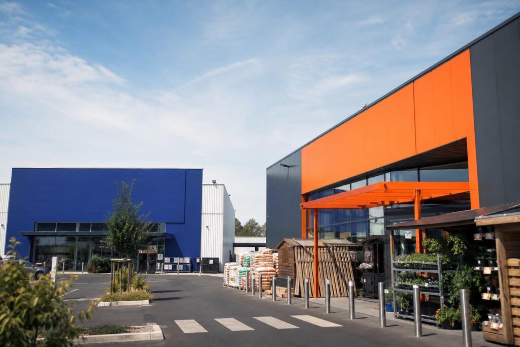 Façades de deux grandes enseignes de bricolage françaises côte à côte.