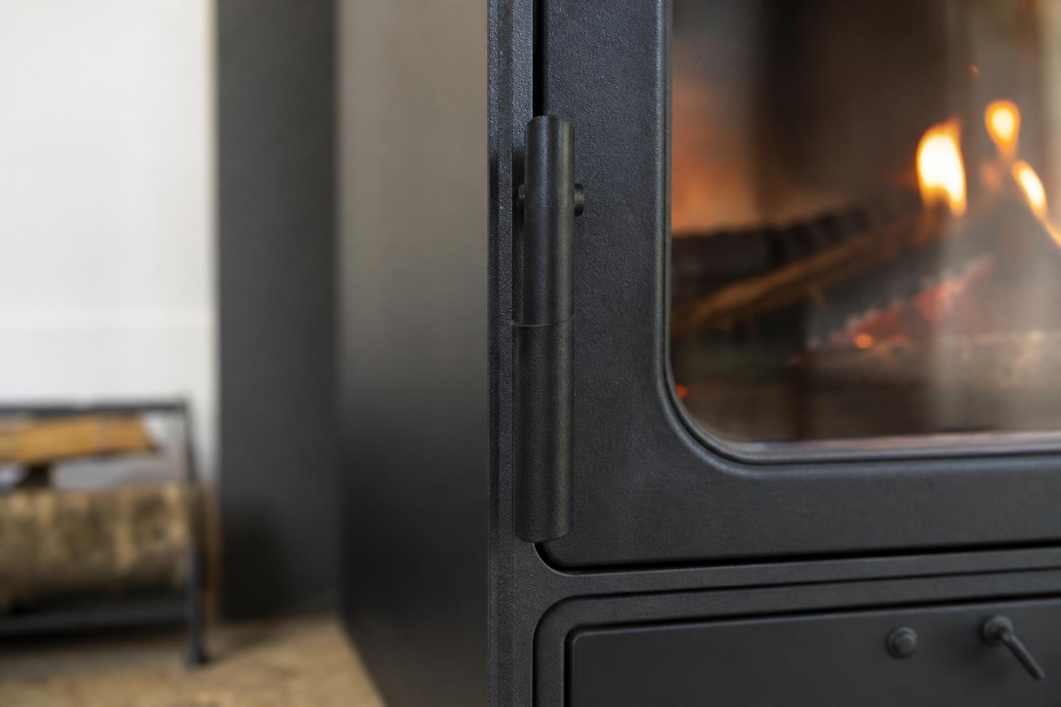 Gros plan sur la porte en fonte d'un poêle à bois avec son étiquette de performance