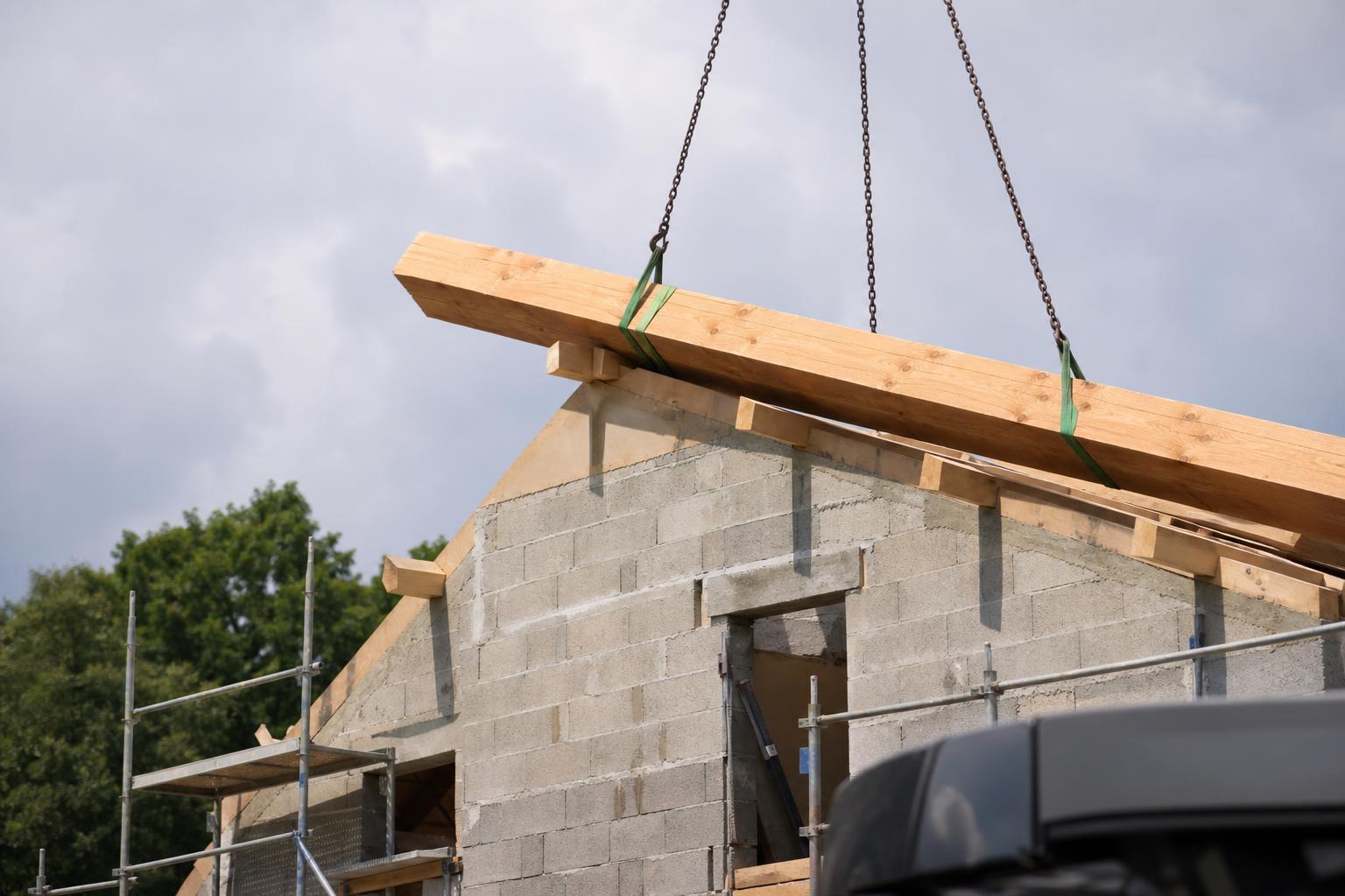 Grosse panne en bois reposant sur un mur pignon d'une maison en construction