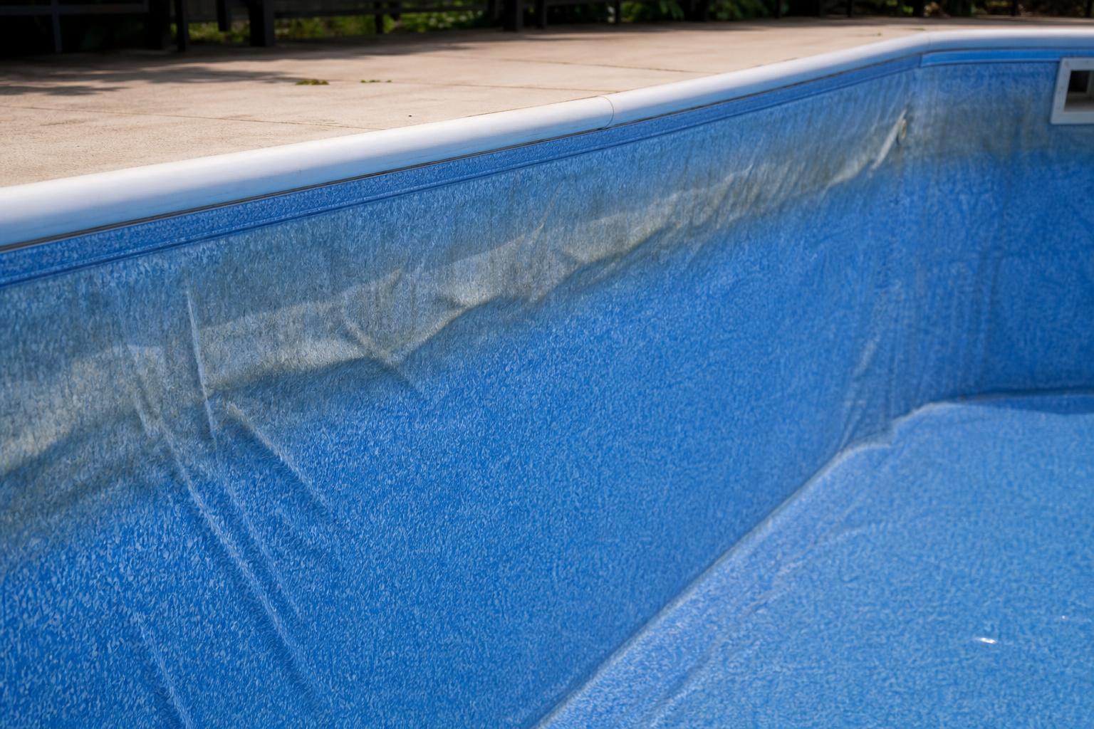 Liner de piscine présentant des plis et une décoloration à la ligne d'eau