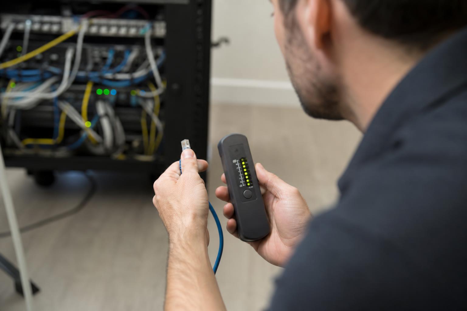 Testeur de câble réseau vérifiant une prise RJ45 avec ses voyants allumés